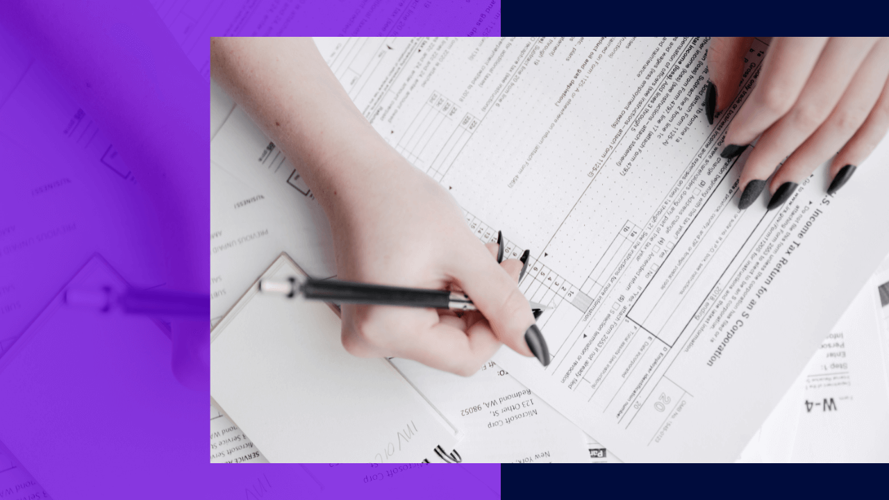 A woman is filling out a tax form, with her hands visible holding a pencil and part of the form in the image.