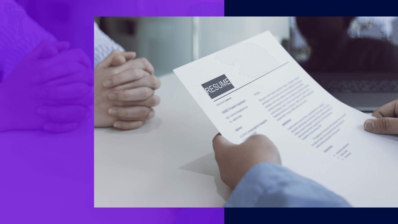 A person holds up a resume during a job interview while sitting across from the interviewer, who has their hands folded in their lap.