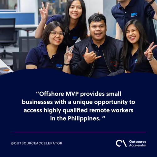 A group of four people, smiling, wearing blue shirts with the logo MVP. They are standing in an office setting with tables and chairs behind them. 